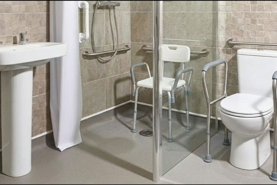 Banheiro adaptado para idosos com barras de apoio,  e cadeira de banho